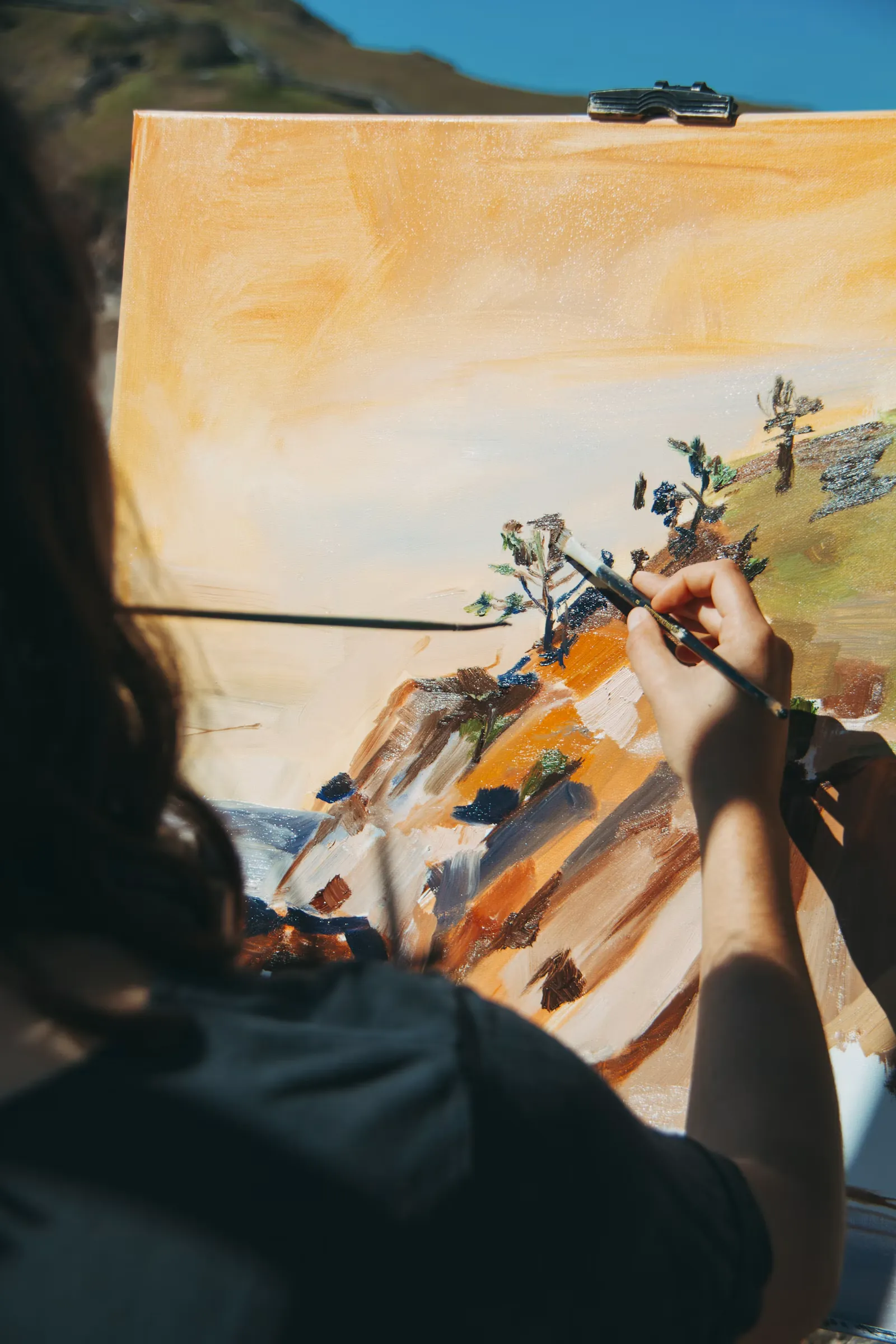 Mujer pintando un paisaje en un lienzo