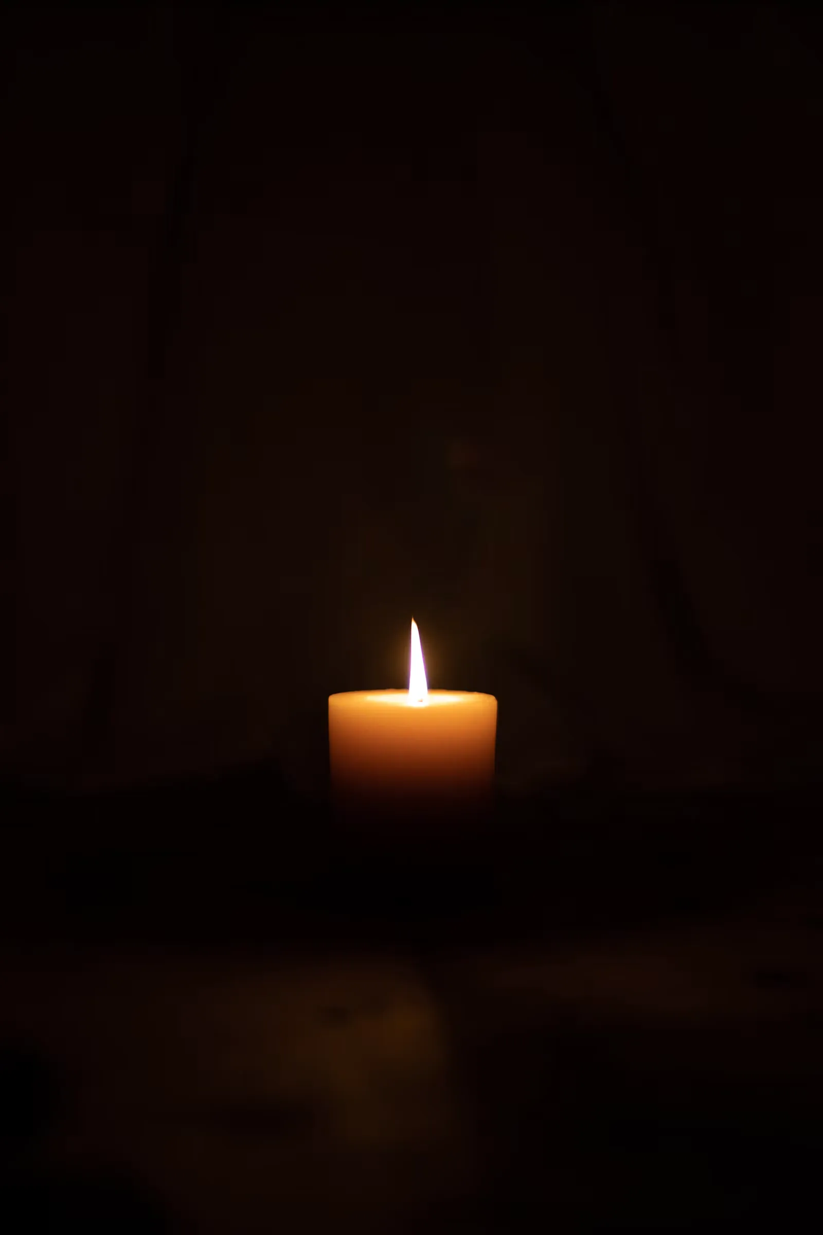 Vela encendida en una habitación oscura