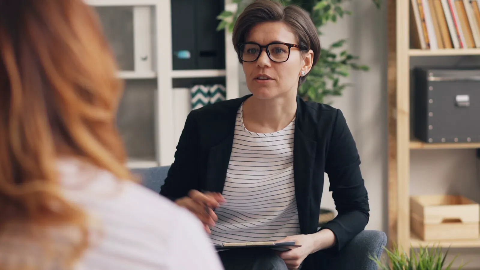 Una mujer conversa con otra en un sofá, en un espacio de acompañamiento